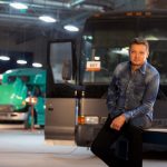 Jeremy Renner stands beside a bus he's remodeling for Disney's Rennervations