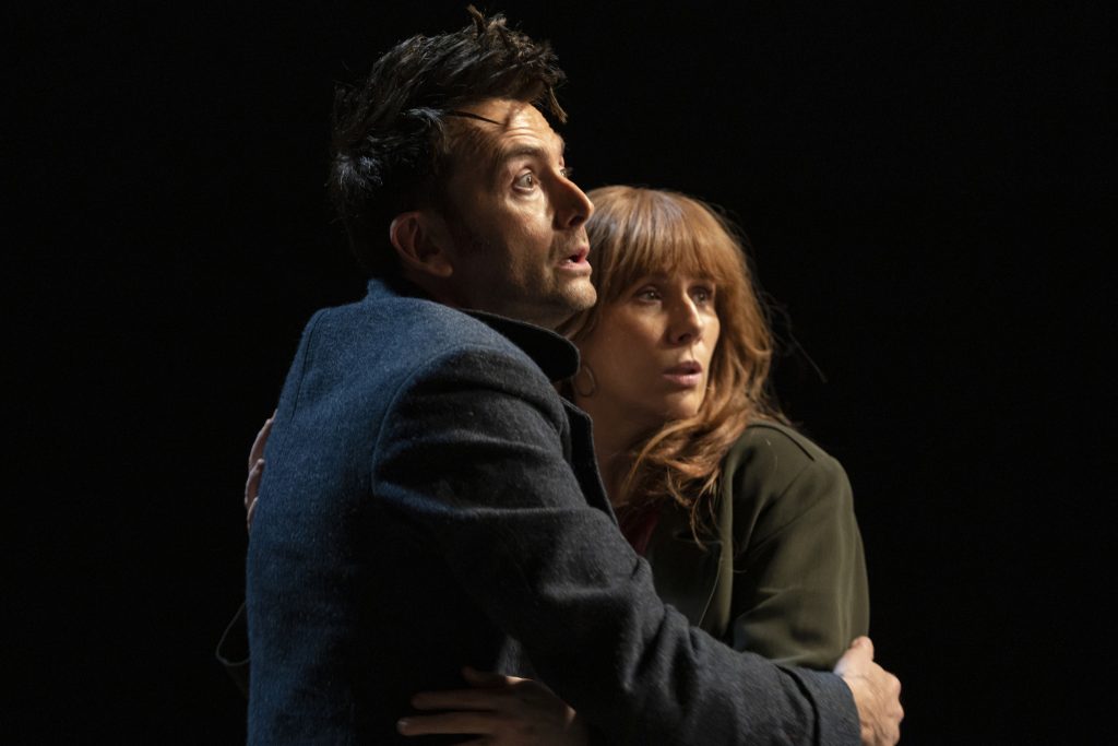 David Tennant and Catherine Tate in a scared embrace. 