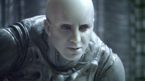 An Engineer, which is a pale, bald creature in a strange silver space suit and black eyes