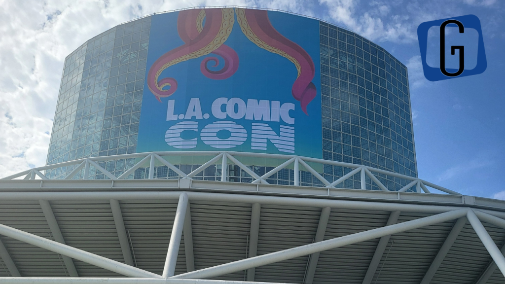 The outside of the Los Angeles Convention Center - a tower of glass windows - with a banner for LA Comic Con with tentacles coming down it. 