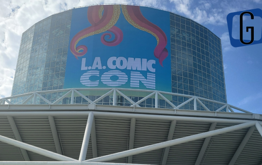 The outside of the Los Angeles Convention Center - a tower of glass windows - with a banner for LA Comic Con with tentacles coming down it.