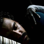 Kenneth Trujillo (as Richard) asleep as a grim hand grabs him.