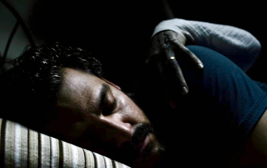 Kenneth Trujillo (as Richard) asleep as a grim hand grabs him.