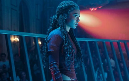 Lit by blue tones, Marie Moreau prepares to fight in an arena. Image courtesy of Amazon Prime Video.