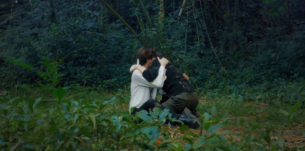 Punn and Ramil embrace in a clearing in the middle of the forest.
