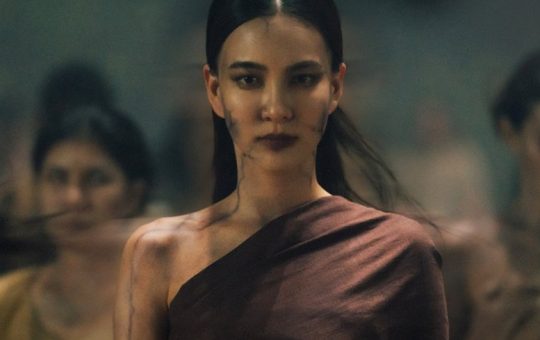 Still from Khemjira: a ghostly woman has come to claim Khem. She is wearing a toga-like garment. There are black lines along her skin. Other ghostly women are behind her.