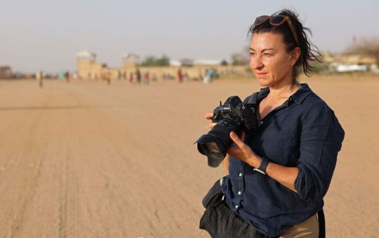 Lyndsey Addario, a war correspondent, stands in the sands of Afaganistan.