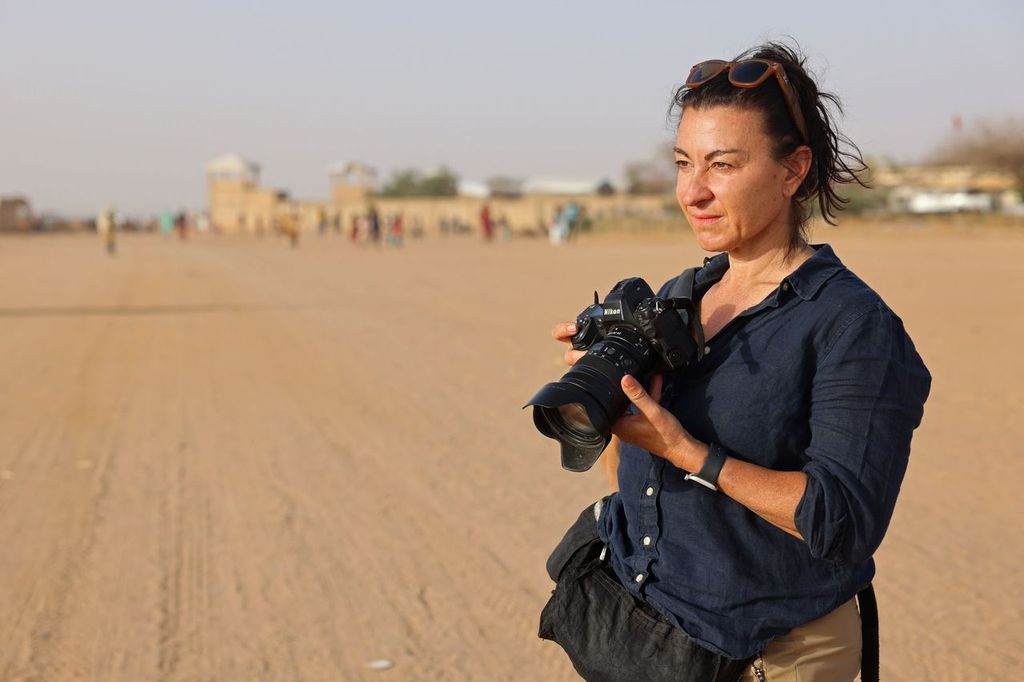Lyndsey Addario, a war correspondent, stands in the sands of Afaganistan.
