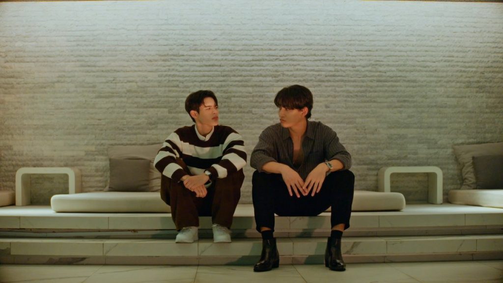 North and Yu sit side by side on the steps outside Pai's apartment building.