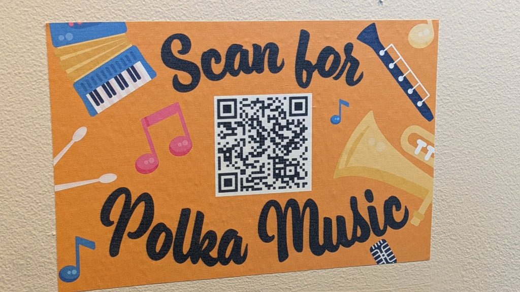 A QR code on an orange background that says "Scan for Polka Music" 