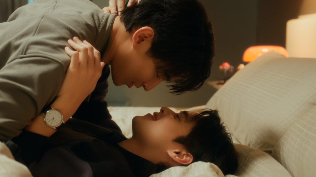 North and Yu are in bed. Yu is hovering above North, who has his arms wrapped around Yu's neck.