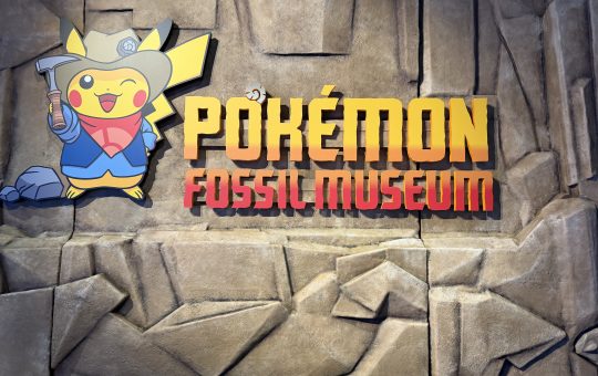 Pokemon fossil museum entrance featuring Pikachu dressed in a tan excavator hat, blue shit, and red handkerchief.